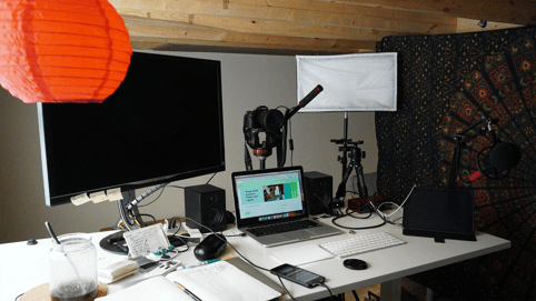 A computer and a monitor on a desk, as a creator gets ready to fill out forms for a performance rights organization, PRO license